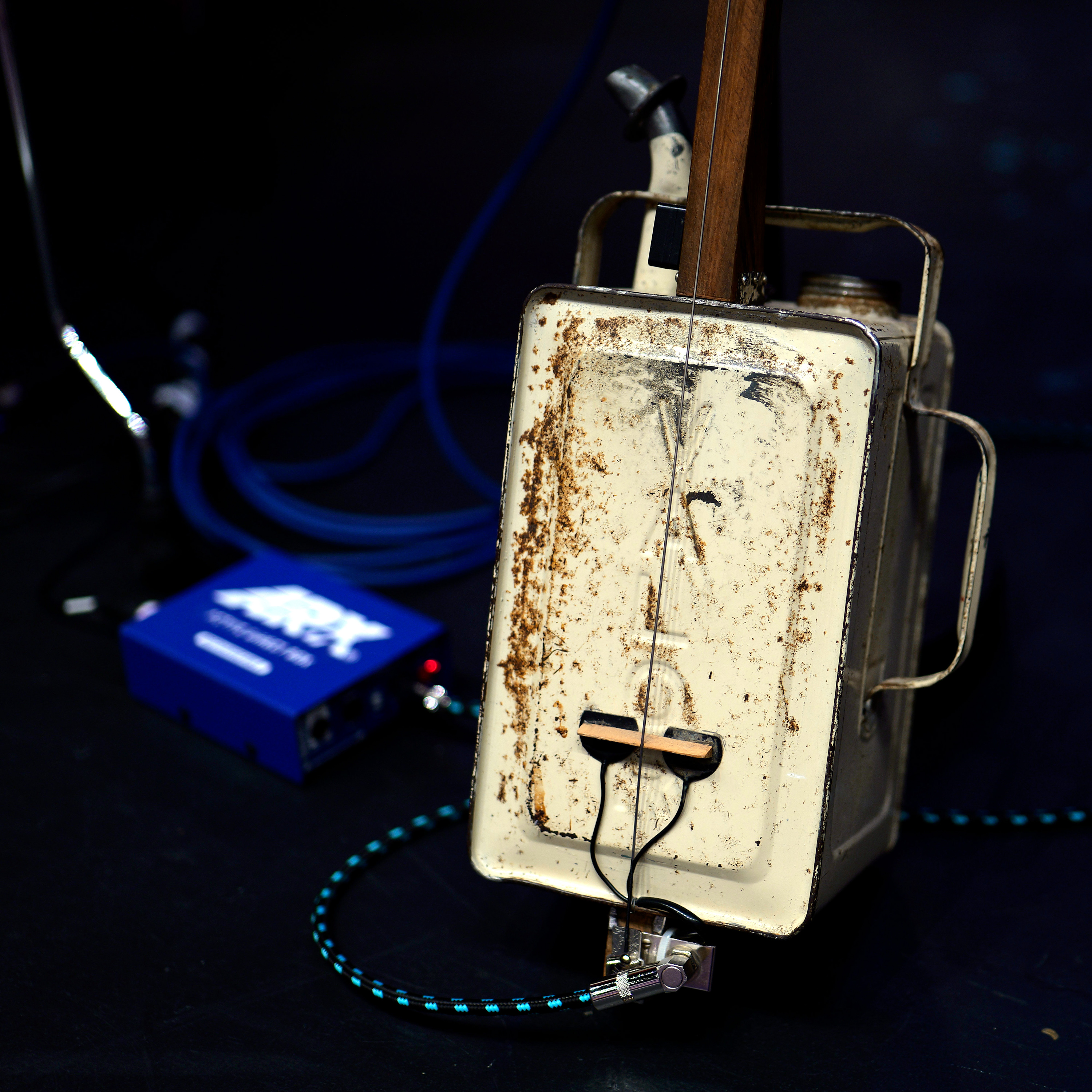 Handmade oil-tin-can bass guitar with single string and electronic pickup