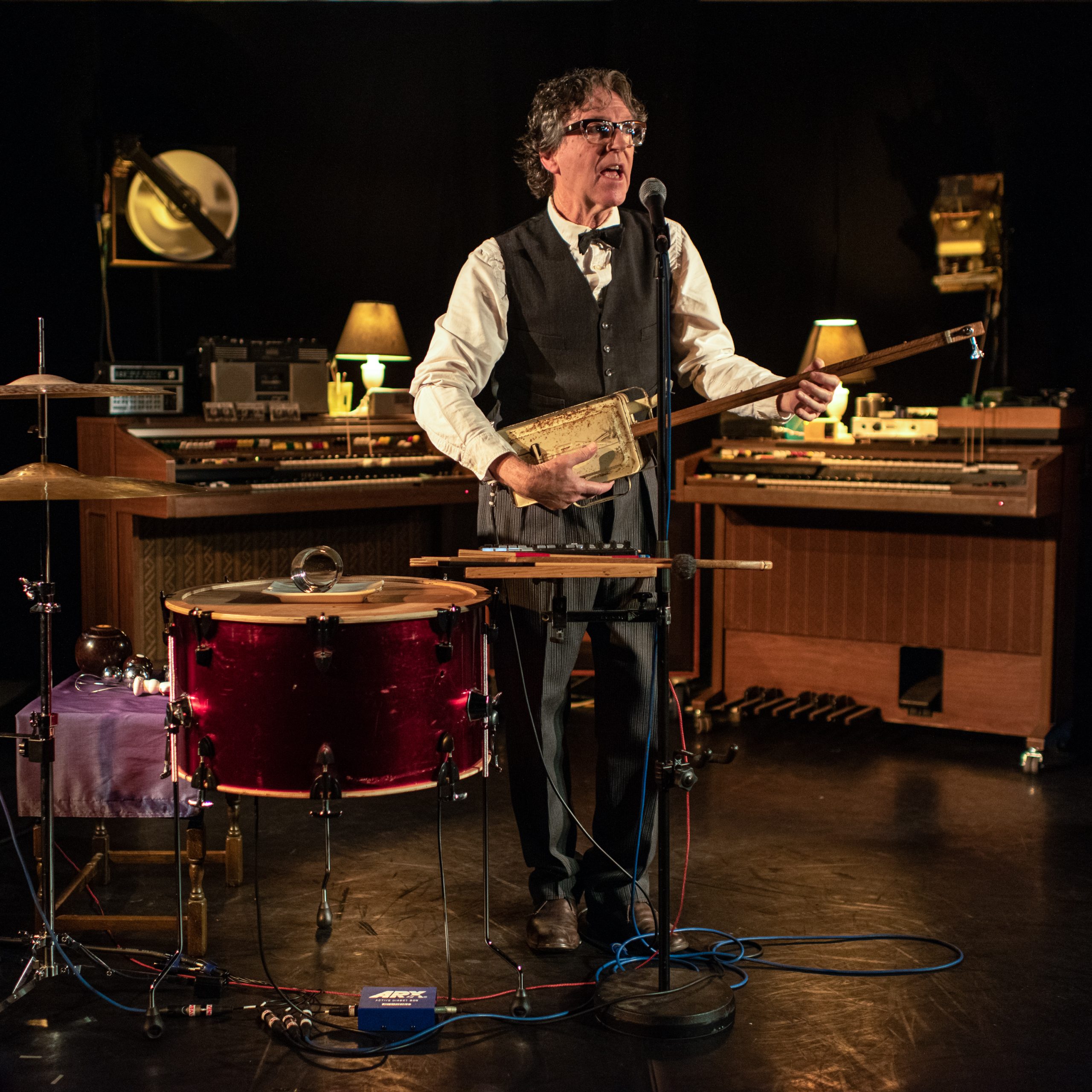 Musician playing one sting tin-can bass and singing on stage