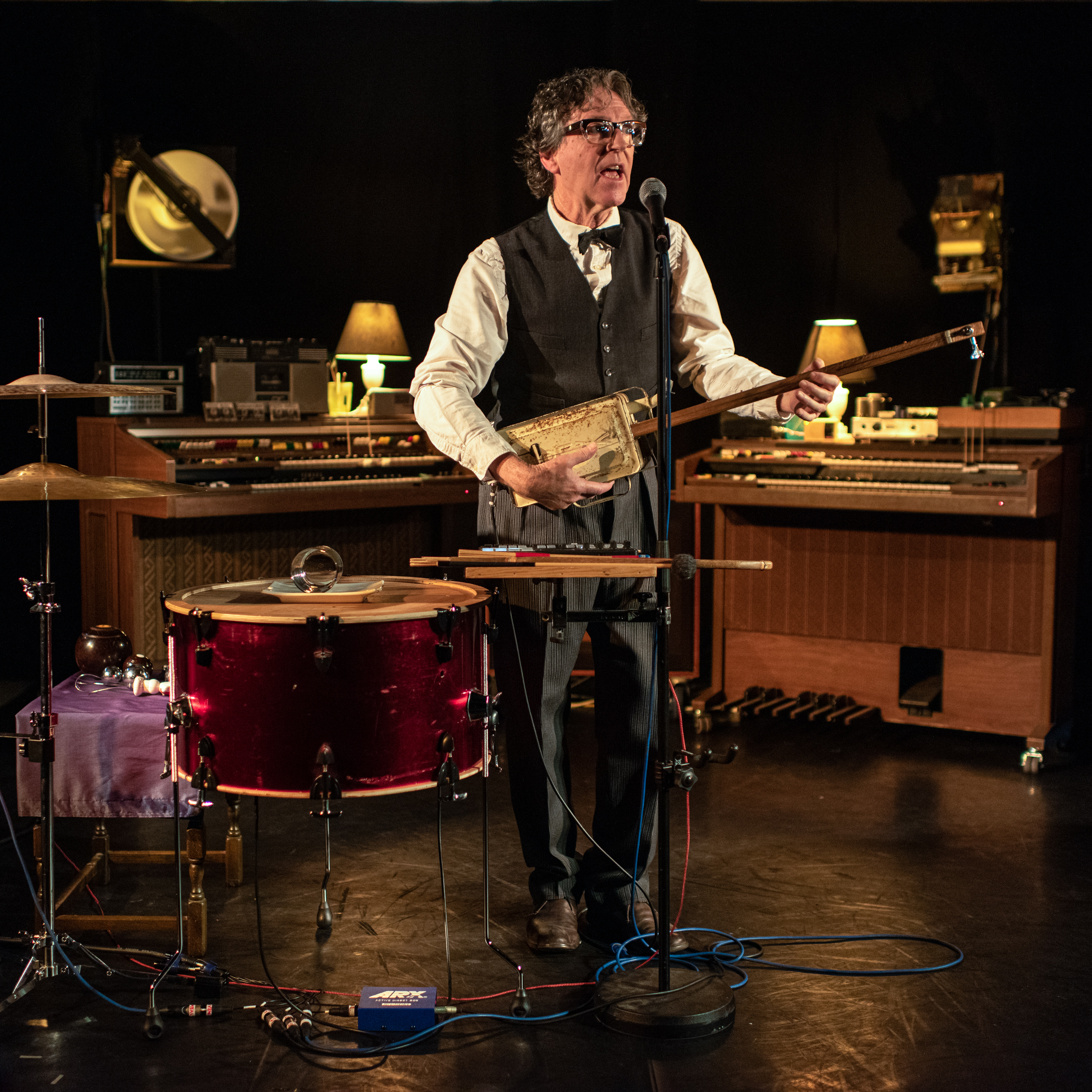 Musician playing one sting tin-can bass and singing on stage