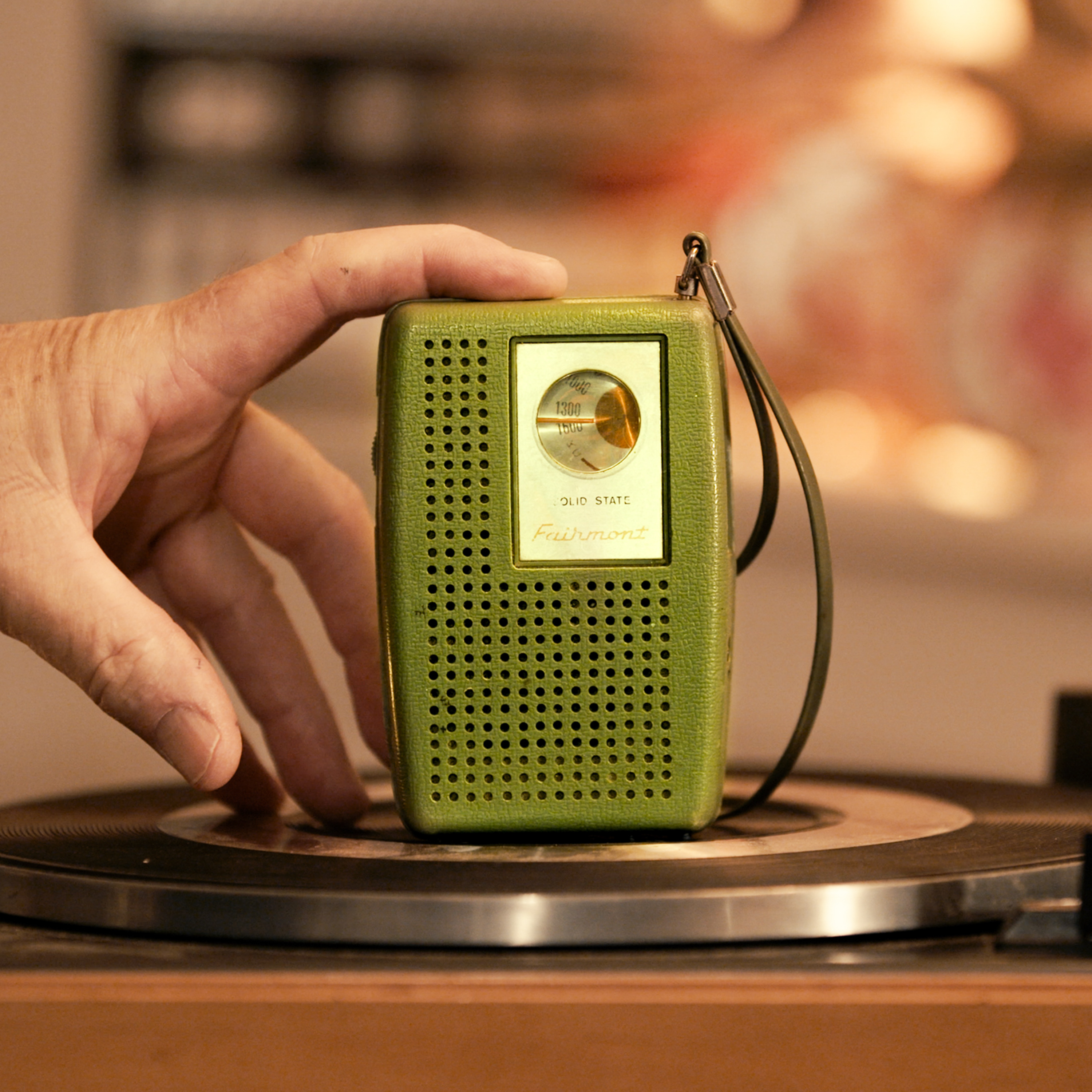 Vintage green radio resting on a turntable